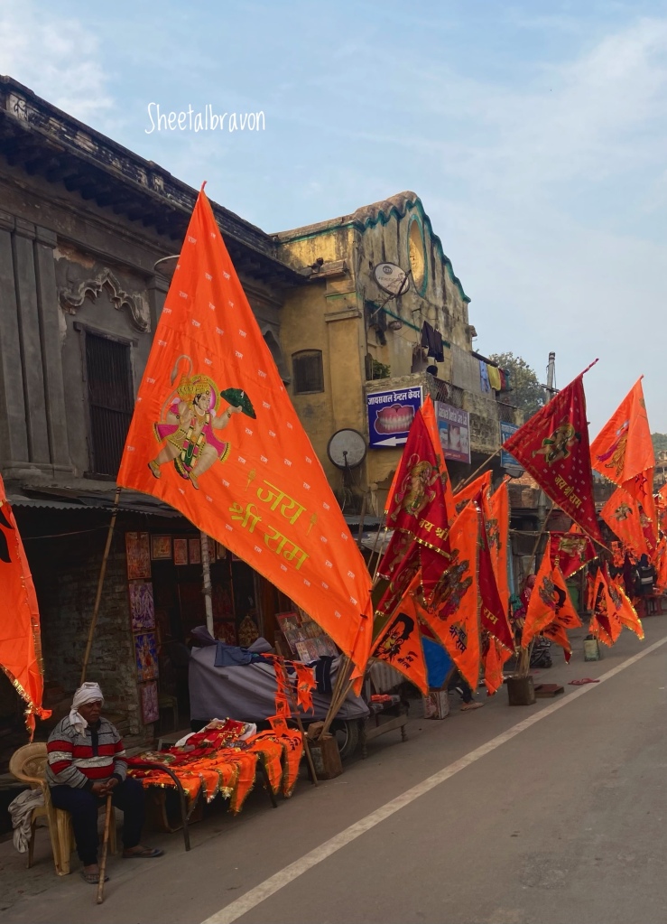 Rows of saffron and red flags with pictures of Ram, Hanuman and Jai Shri Ram printed on them, line alongside the road, for sale in Ayodhya.